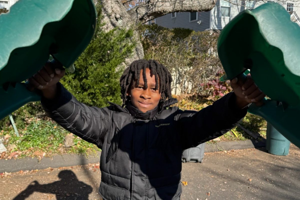 Zion is holding his Hulk Hands--tools he puts together to help him pick up leaves--for Community Service Day. Caption by Ky'Reese.